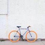 yellow and purple bicycle near white wall at daytime