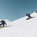 three person riding on snowboard