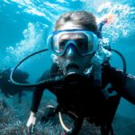 person in black and white diving suit wearing goggles