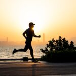 a man running on the beach at sunset