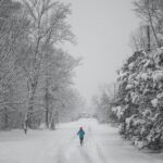 person jogging on snow capped pathway