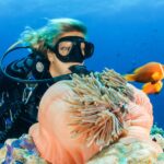 female diver near sea sponge during daytime