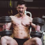 man holding two dumbbells