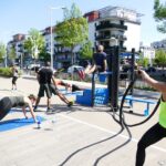 people sitting on blue plastic chairs near black metal post during daytime