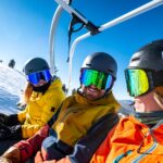 2 person in yellow jacket wearing helmet riding on cable car during daytime