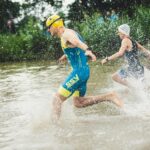 man in blue shorts running on water during daytime