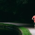 person in red shirt standing near river during daytime